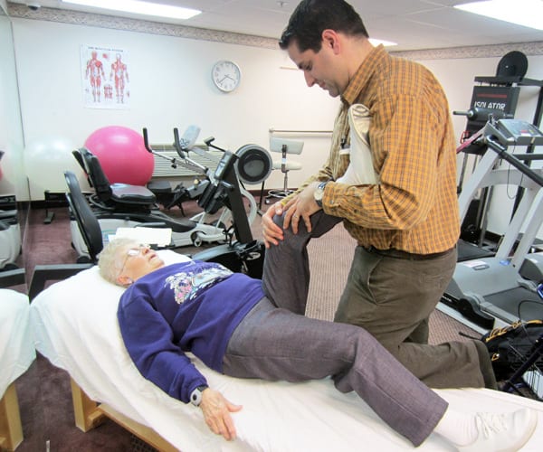 therapist working on elderly womans knee